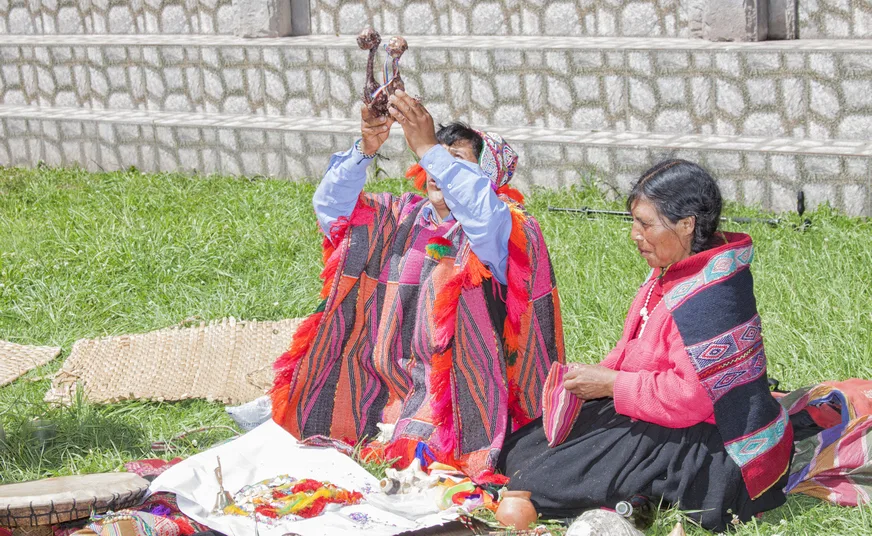 Pachamama earth offering ceremony with coca leaves and chicha in Cusco
